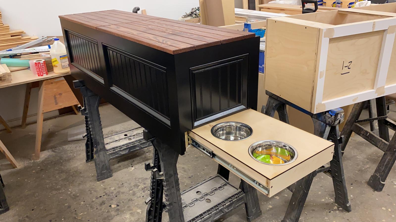 Photo of Traditional style straight bench painted black with a retractable two-bowl pet drawer built into the right sight end panel.