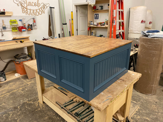 Photo of custom extra-wide straight bench painted a custom blue color with a wood-stained top