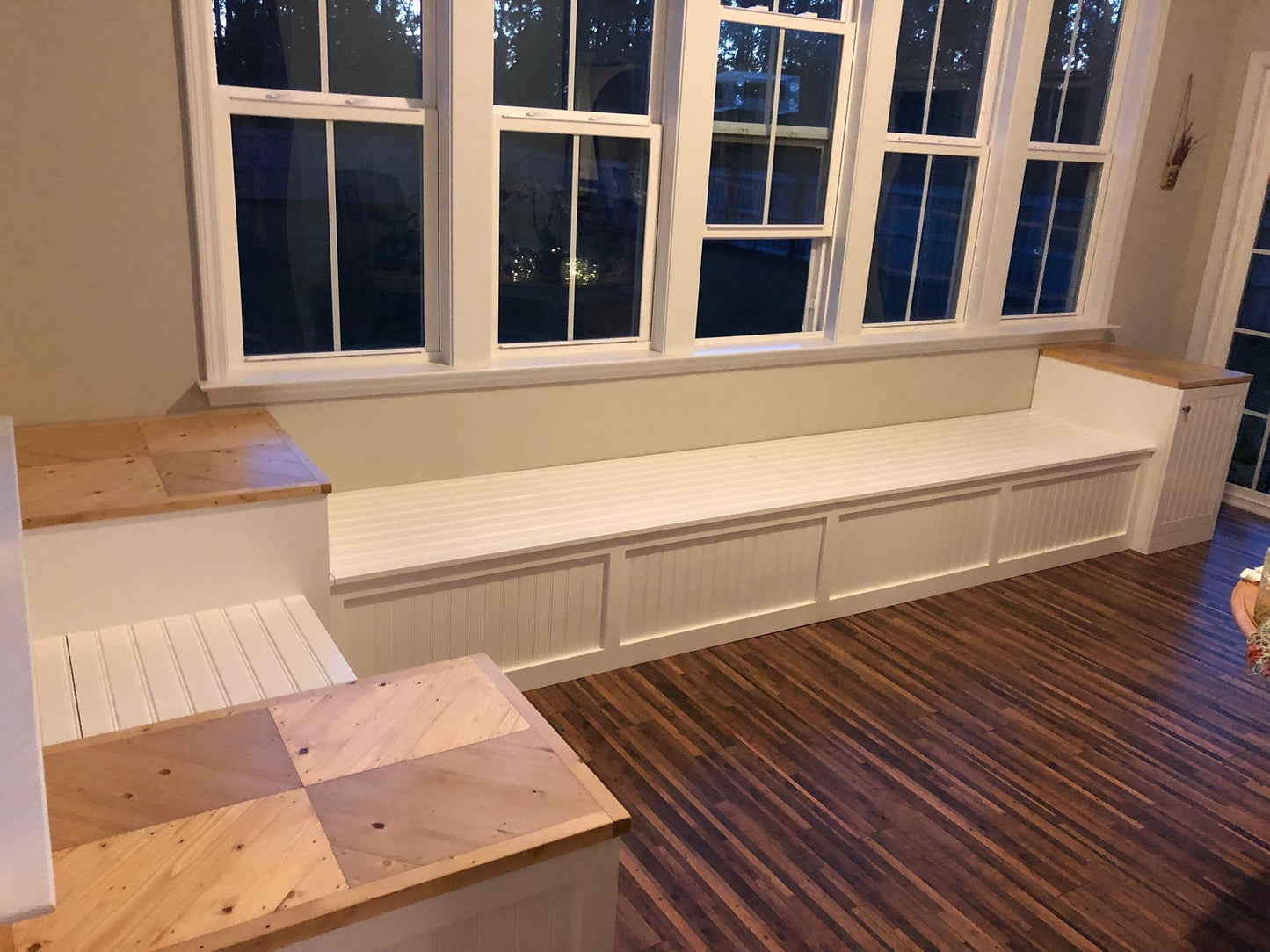 Photo of a Traditional style L-shape corner bench with custom raised end tables in front of a wall of windows